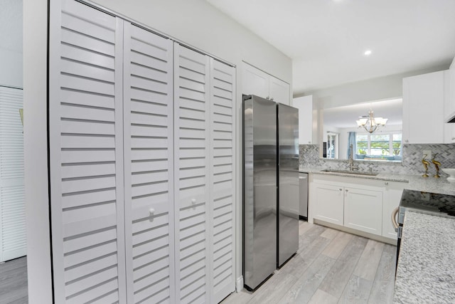 5890 Sugar Palm Ct Unit E, Delray Beach, FL 33484 - kitchen with stainless steel appliances, a sink, light wood finished floors, a chandelier, and decorative backsplash