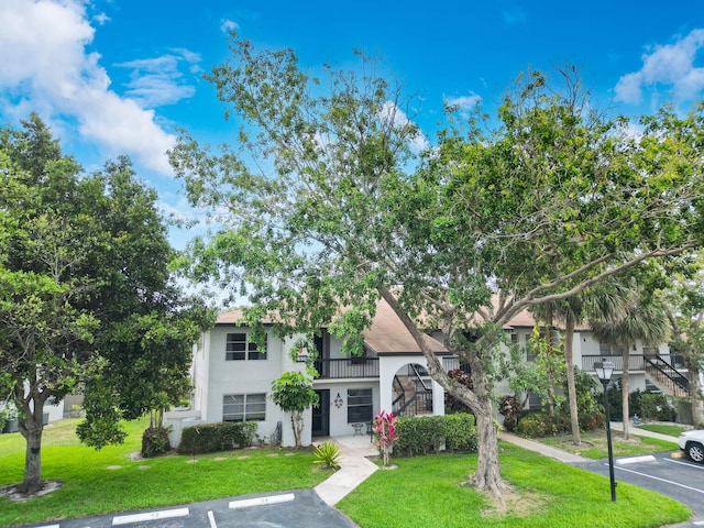 5890 Sugar Palm Ct Unit E, Delray Beach, FL 33484 - view of front of home featuring stucco siding, uncovered parking, stairs, and a front yard