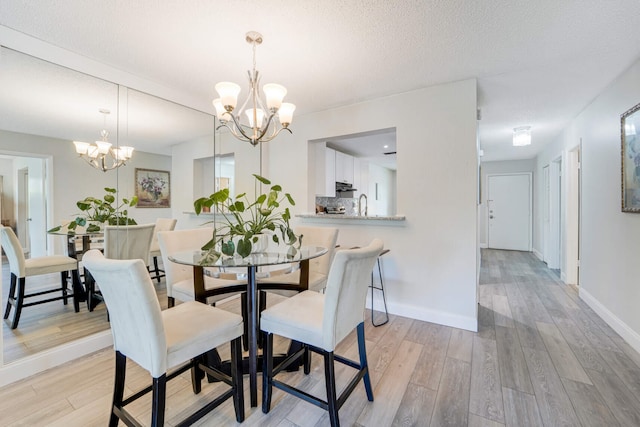 5890 Sugar Palm Ct Unit E, Delray Beach, FL 33484 - dining room featuring a chandelier, light wood-type flooring, baseboards, and a textured ceiling