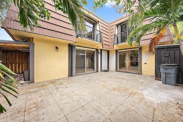 1021 10th Ct Unit 1021, Palm Beach Gardens, FL 33410 - rear view of property featuring stucco siding, mansard roof, a balcony, a patio area, and a tile roof