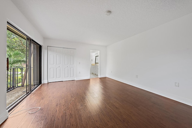 1021 10th Ct Unit 1021, Palm Beach Gardens, FL 33410 - unfurnished bedroom featuring multiple windows, baseboards, wood finished floors, and a textured ceiling