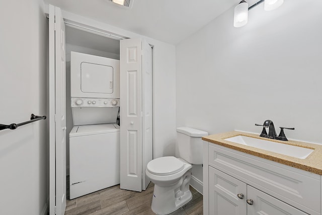1021 10th Ct Unit 1021, Palm Beach Gardens, FL 33410 - bathroom with stacked washer / dryer, vanity, wood finished floors, and toilet