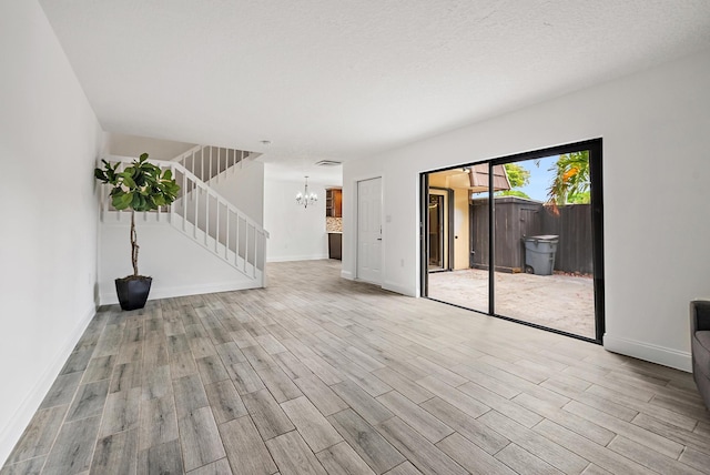 1021 10th Ct Unit 1021, Palm Beach Gardens, FL 33410 - empty room with stairs, wood finished floors, a chandelier, and baseboards
