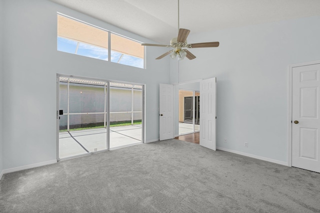 2045 SW Olympic Club Ter, Palm City, FL 34990 - unfurnished bedroom featuring carpet floors, a high ceiling, baseboards, access to exterior, and ceiling fan