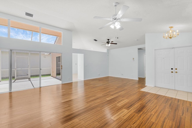 2045 SW Olympic Club Ter, Palm City, FL 34990 - unfurnished living room with a chandelier, light wood-type flooring, ceiling fan, lofted ceiling, and baseboards
