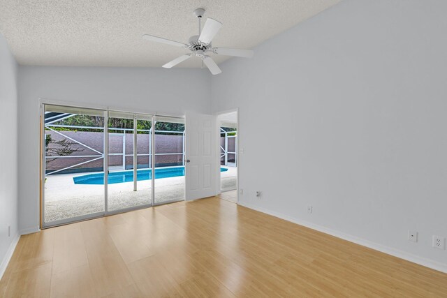 2281 SW Olympic Club Ter, Palm City, FL 34990 - spare room featuring wood finished floors, baseboards, a ceiling fan, a textured ceiling, and high vaulted ceiling