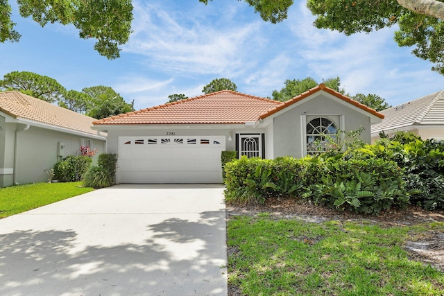 2281 SW Olympic Club Ter, Palm City, FL 34990 - mediterranean / spanish-style home featuring a tiled roof, an attached garage, stucco siding, and concrete driveway