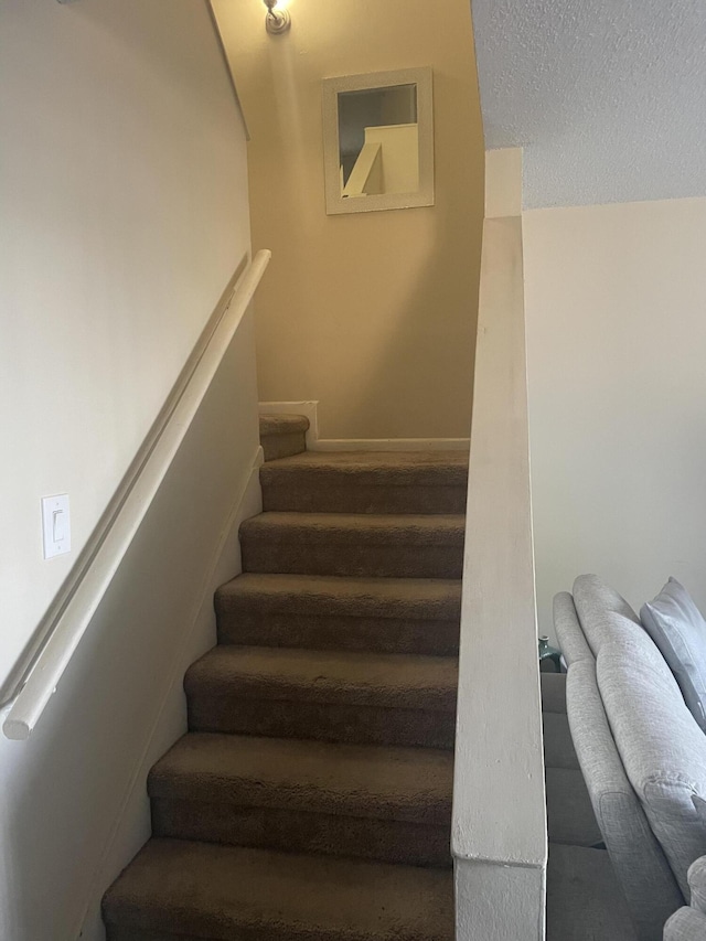1701 Village Blvd Unit 112, West Palm Beach, FL 33409 - staircase with a textured ceiling and baseboards
