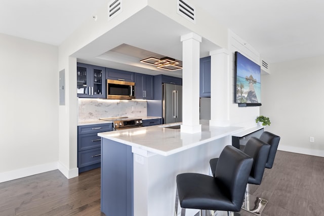 899 Jeffery St Unit 414, Boca Raton, FL 33487 - kitchen with blue cabinets, appliances with stainless steel finishes, decorative columns, a breakfast bar area, and a peninsula