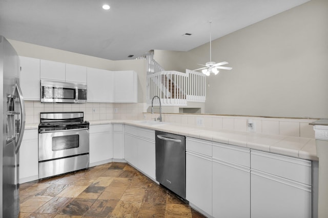 2274 SW Olympic Club Ter, Palm City, FL 34990 - kitchen featuring appliances with stainless steel finishes, a sink, stone finish flooring, decorative backsplash, and tile countertops