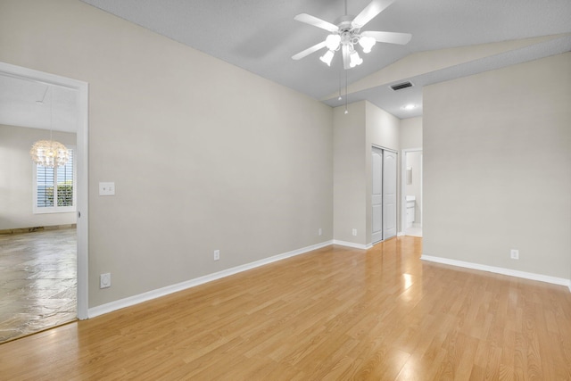 2274 SW Olympic Club Ter, Palm City, FL 34990 - empty room with a ceiling fan, a chandelier, light wood-style flooring, baseboards, and high vaulted ceiling