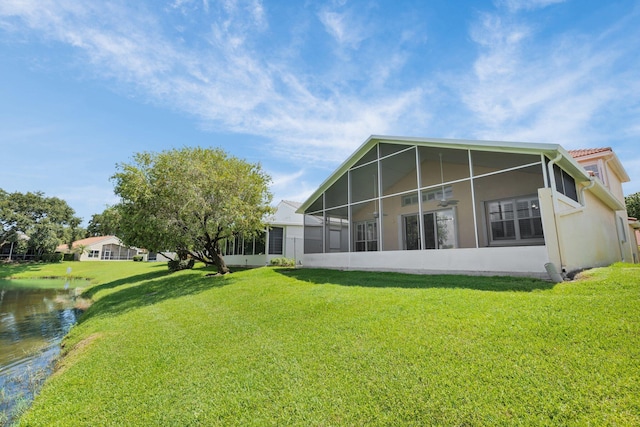 2274 SW Olympic Club Ter, Palm City, FL 34990 - rear view of property with a sunroom, a yard, stucco siding, and a water view