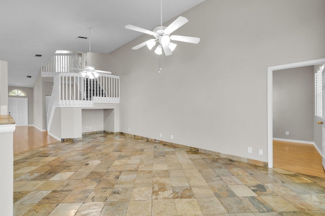 2274 SW Olympic Club Ter, Palm City, FL 34990 - unfurnished living room with high vaulted ceiling, ceiling fan, baseboards, and light stone finish flooring