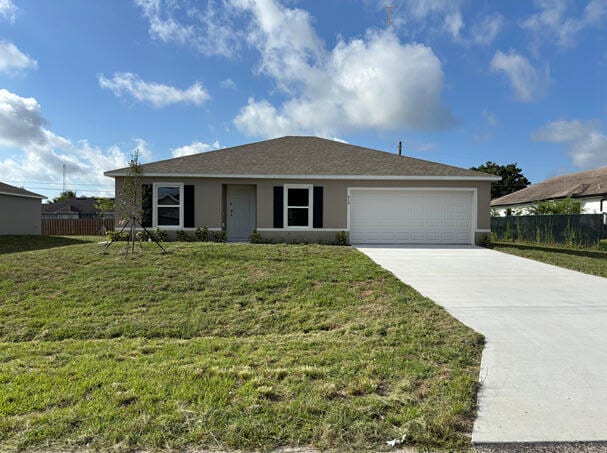 934 SW Mcdevitt Ave, Port Saint Lucie, FL 34953 - ranch-style house featuring concrete driveway, an attached garage, and stucco siding