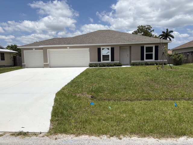 565 SW Fairview Ave, Port Saint Lucie, FL 34983 - ranch-style home with an attached garage, driveway, stucco siding, and a shingled roof