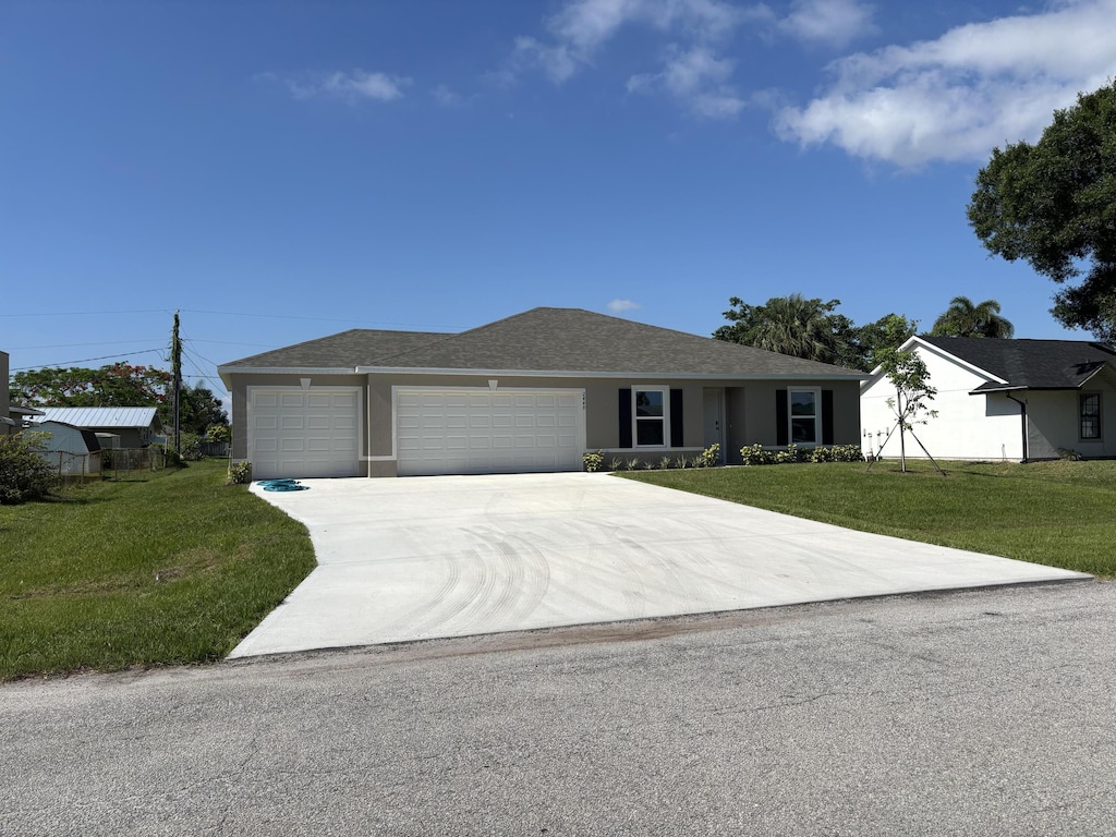 2448 SE Pascal Ave, Port Saint Lucie, FL 34952 - ranch-style house with an attached garage, a front yard, driveway, and stucco siding