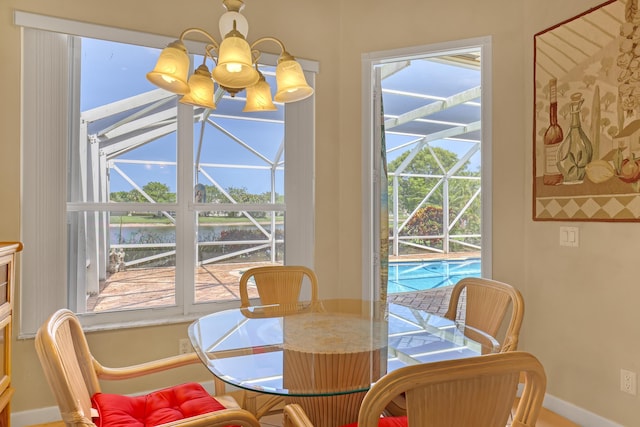 9466 Lantern Bay Cir, West Palm Beach, FL 33411 - dining space with a sunroom, a water view, and baseboards