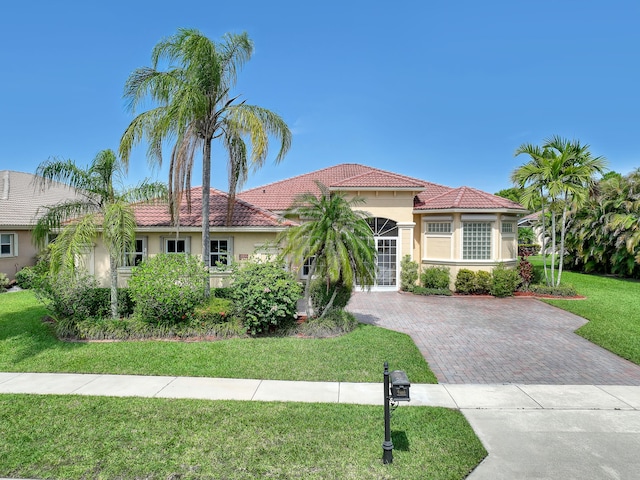 9466 Lantern Bay Cir, West Palm Beach, FL 33411 - mediterranean / spanish-style house with stucco siding, a tile roof, a front yard, and driveway