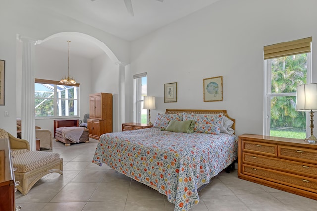 9466 Lantern Bay Cir, West Palm Beach, FL 33411 - bedroom featuring ornate columns, light tile patterned floors, a towering ceiling, a ceiling fan, and a chandelier