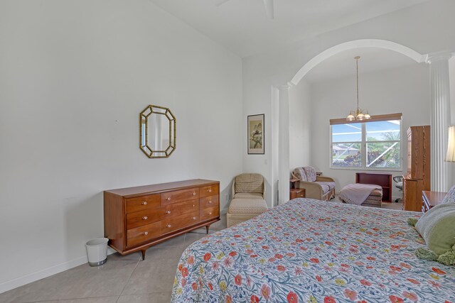 9466 Lantern Bay Cir, West Palm Beach, FL 33411 - bedroom featuring ornate columns, light tile patterned floors, a chandelier, arched walkways, and baseboards