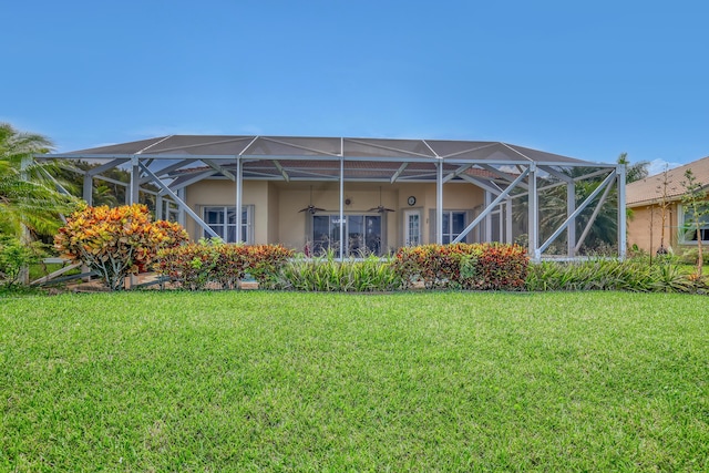 9466 Lantern Bay Cir, West Palm Beach, FL 33411 - back of property with a ceiling fan, a lawn, stucco siding, and a lanai