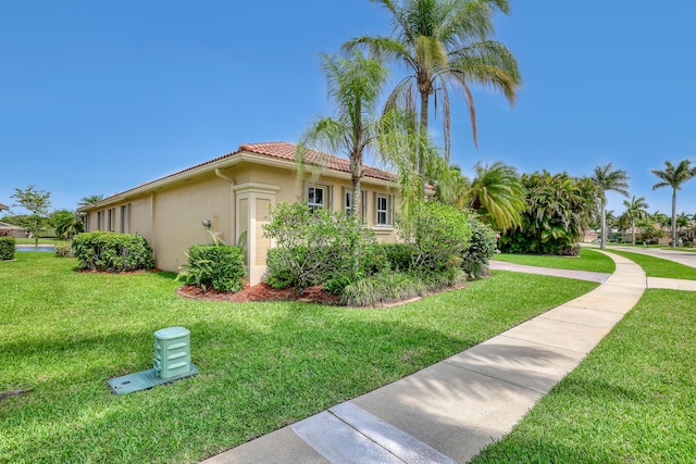 9466 Lantern Bay Cir, West Palm Beach, FL 33411 - view of side of home featuring stucco siding, a lawn, and a tiled roof