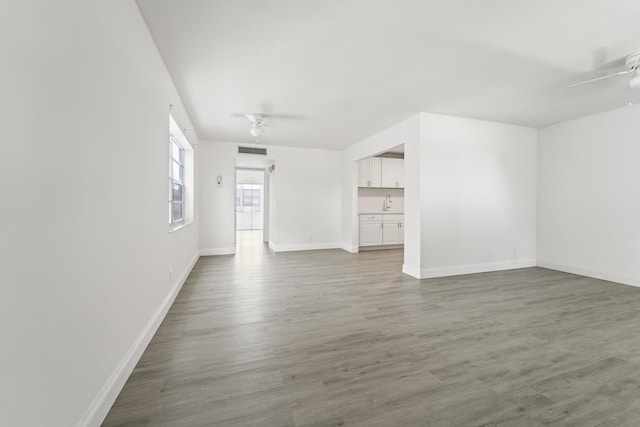 938 Normandy T 938, Delray Beach, FL 33484 - unfurnished living room with a ceiling fan, wood finished floors, and baseboards
