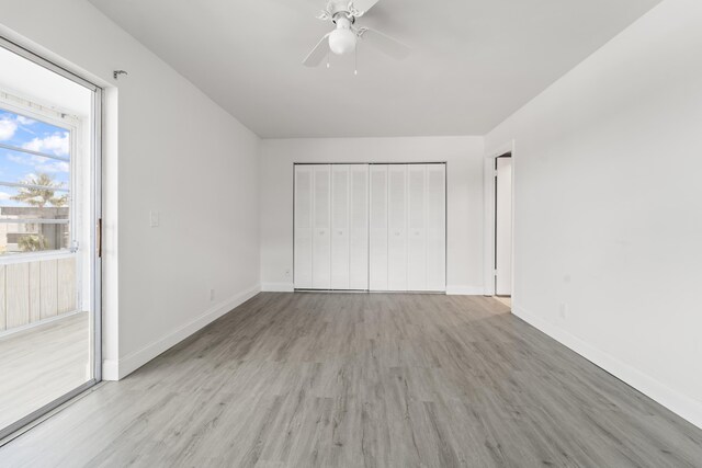 938 Normandy T 938, Delray Beach, FL 33484 - unfurnished bedroom featuring light wood-style floors, baseboards, access to exterior, a closet, and a ceiling fan