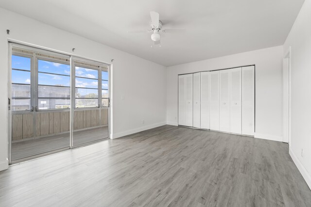 938 Normandy T 938, Delray Beach, FL 33484 - unfurnished bedroom featuring wood finished floors, baseboards, access to outside, a closet, and ceiling fan