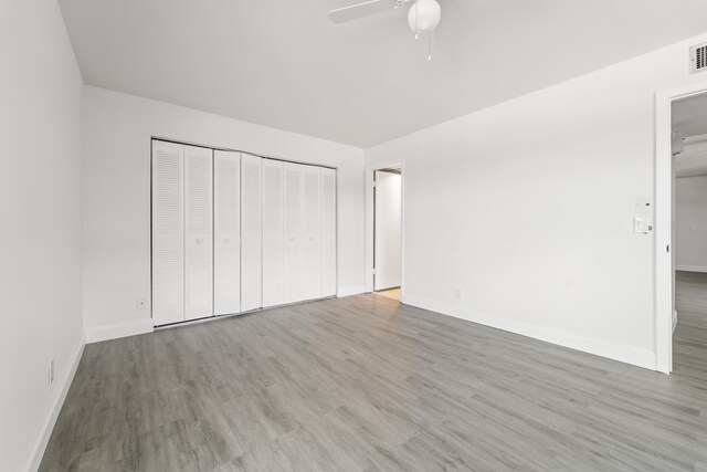 938 Normandy T 938, Delray Beach, FL 33484 - unfurnished bedroom featuring wood finished floors, a closet, baseboards, and ceiling fan
