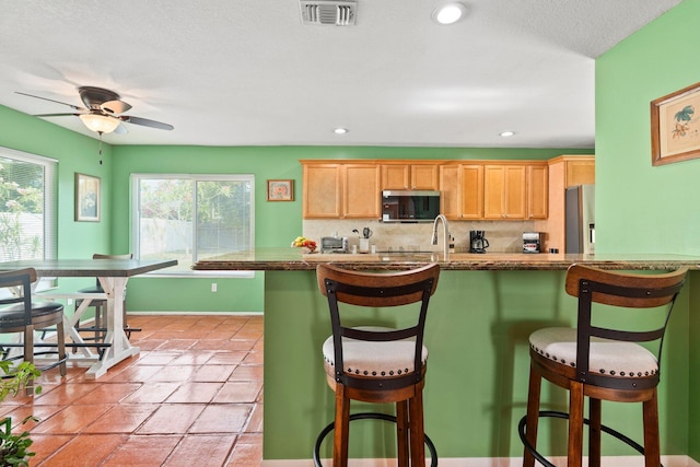 333 SE Dalva Ave, Port Saint Lucie, FL 34984 - kitchen with stainless steel appliances, plenty of natural light, a ceiling fan, and backsplash