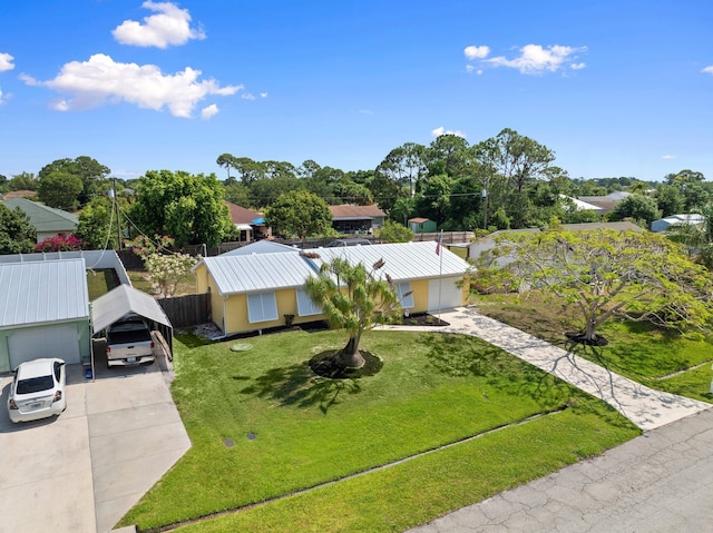 333 SE Dalva Ave, Port Saint Lucie, FL 34984 - view of front facade with a carport, concrete driveway, a front yard, and metal roof