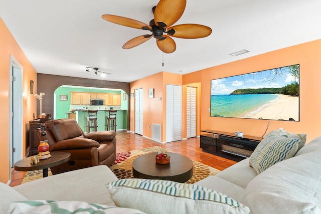 333 SE Dalva Ave, Port Saint Lucie, FL 34984 - living area with light tile patterned flooring, ceiling fan, arched walkways, and baseboards