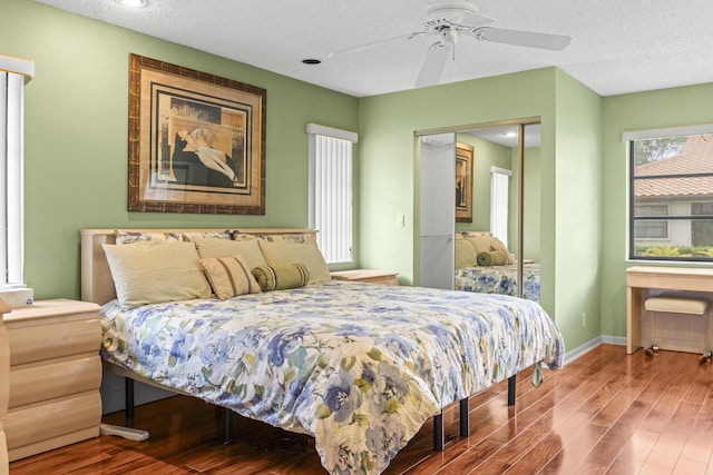 6067 Kings Gate Cir, Delray Beach, FL 33484 - bedroom with wood finished floors, baseboards, ceiling fan, a textured ceiling, and a closet
