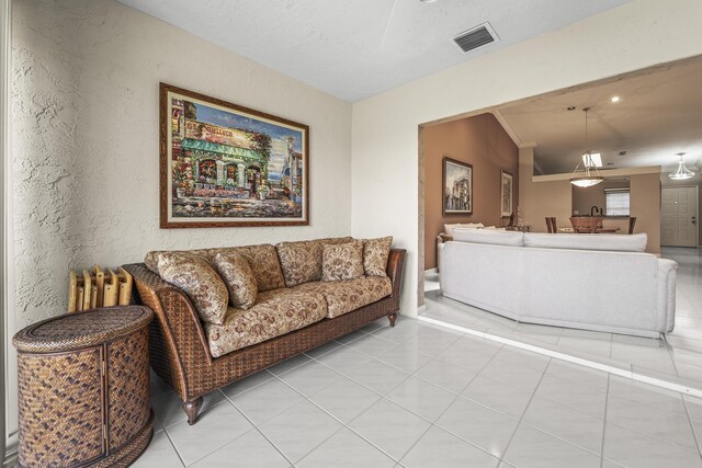 6067 Kings Gate Cir, Delray Beach, FL 33484 - living room featuring a textured wall, lofted ceiling, and light tile patterned floors