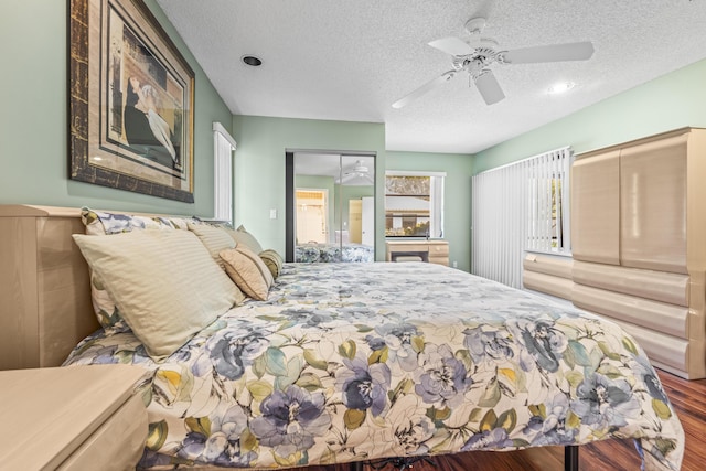 6067 Kings Gate Cir, Delray Beach, FL 33484 - bedroom featuring a textured ceiling, wood finished floors, and a ceiling fan