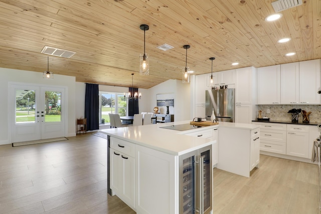 386 NE Ficus Ter, Jensen Beach, FL 34957 - kitchen featuring freestanding refrigerator, a kitchen island, beverage cooler, wooden ceiling, and backsplash