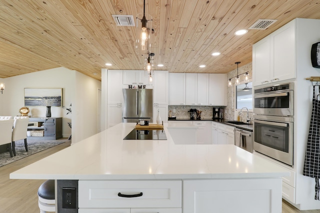 386 NE Ficus Ter, Jensen Beach, FL 34957 - kitchen featuring appliances with stainless steel finishes, a sink, wood ceiling, a center island, and white cabinets