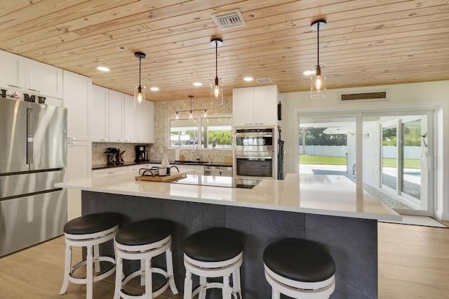 386 NE Ficus Ter, Jensen Beach, FL 34957 - kitchen featuring stainless steel appliances, wooden ceiling, backsplash, white cabinetry, and a kitchen bar
