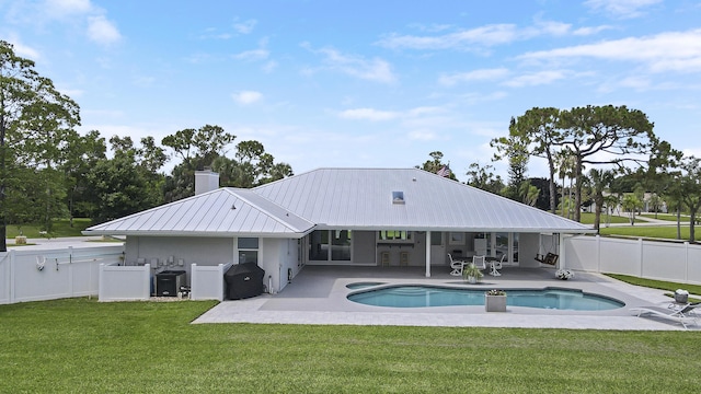 386 NE Ficus Ter, Jensen Beach, FL 34957 - rear view of house featuring a patio area, a chimney, metal roof, and a pool with connected hot tub