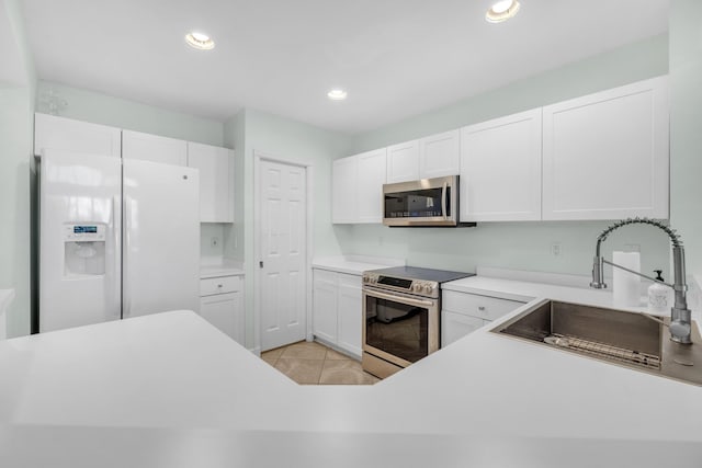 10125 N Military Trl, Palm Beach Gardens, FL 33410 - kitchen with appliances with stainless steel finishes, a sink, white cabinetry, light countertops, and light tile patterned floors