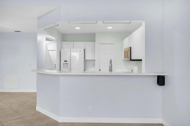 10125 N Military Trl, Palm Beach Gardens, FL 33410 - kitchen featuring white refrigerator with ice dispenser, stainless steel microwave, white cabinetry, a peninsula, and baseboards