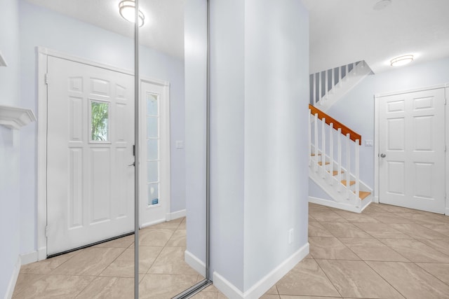 10125 N Military Trl, Palm Beach Gardens, FL 33410 - foyer entrance with stairs, light tile patterned floors, and baseboards