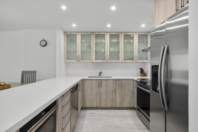 2301 Collins Ave Unit 1239, Miami Beach, FL 33139 - kitchen featuring appliances with stainless steel finishes, light brown cabinets, a sink, light countertops, and recessed lighting