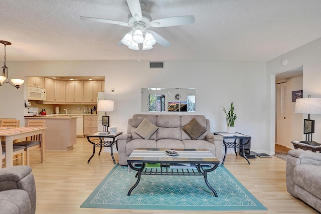 3561 Tall Pine Way Unit B-1, Greenacres, FL 33463 - living area featuring light wood-type flooring, a textured ceiling, ceiling fan, and baseboards