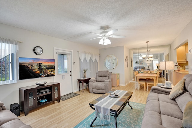 3561 Tall Pine Way Unit B-1, Greenacres, FL 33463 - living area featuring light wood-style floors, a ceiling fan, a chandelier, a textured ceiling, and baseboards