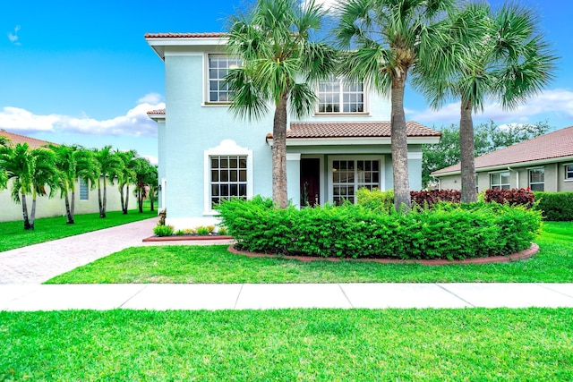 1855 SW Jamesport Dr, Port Saint Lucie, FL 34953 - mediterranean / spanish-style house featuring a tiled roof, stucco siding, and a front lawn