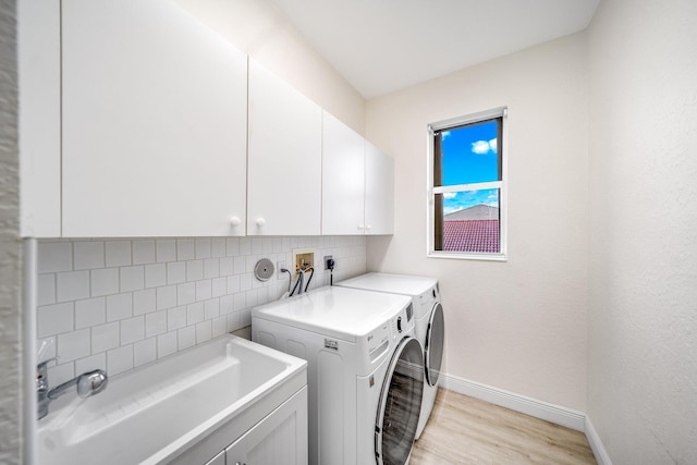 1855 SW Jamesport Dr, Port Saint Lucie, FL 34953 - washroom with cabinet space, baseboards, light wood-style flooring, and washer and dryer