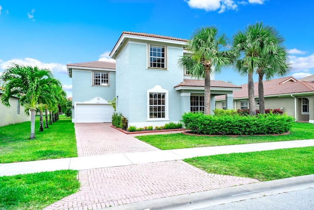 1855 SW Jamesport Dr, Port Saint Lucie, FL 34953 - mediterranean / spanish-style house featuring a tiled roof, decorative driveway, an attached garage, stucco siding, and a front yard