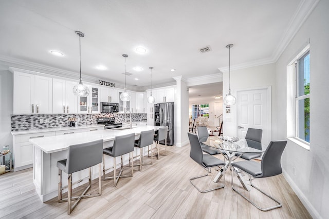 1855 SW Jamesport Dr, Port Saint Lucie, FL 34953 - dining room with baseboards, ornamental molding, light wood-style flooring, and recessed lighting